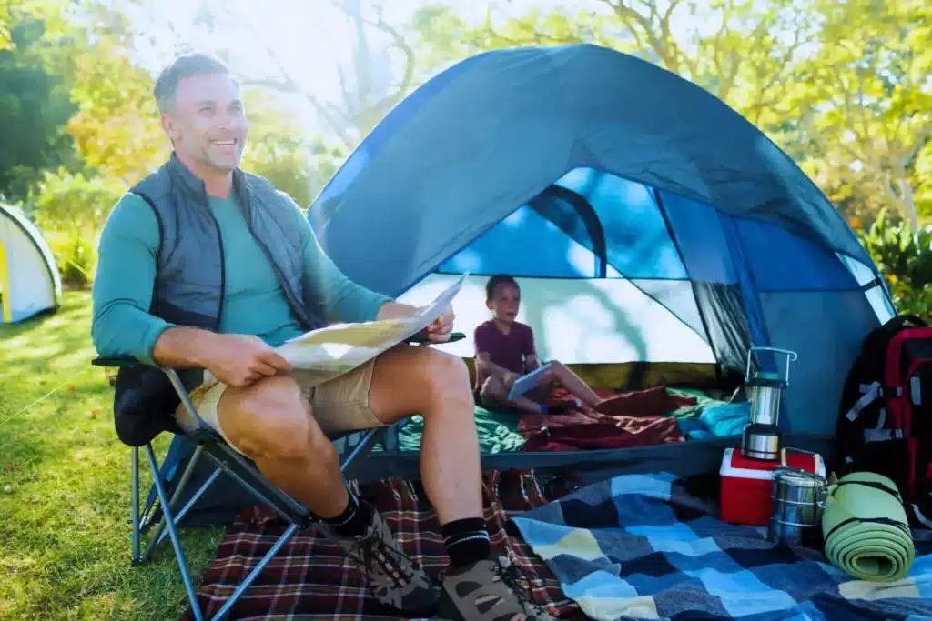 homme qui lit devant une tente scaled