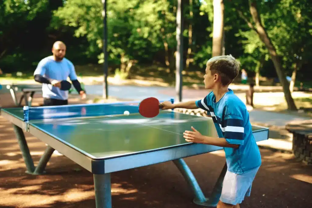 pere et son fils jouant au ping pong scaled